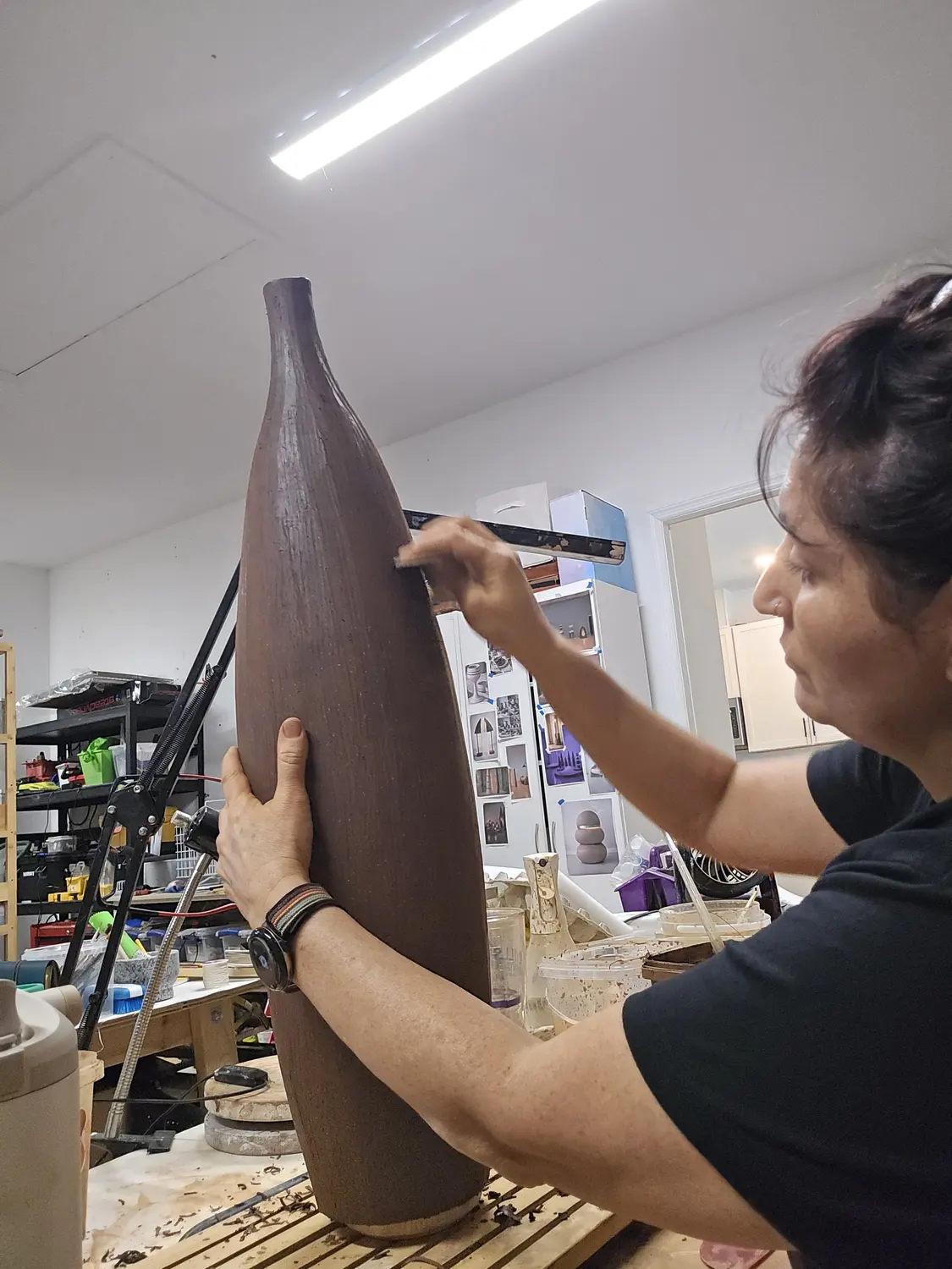 Maria shaping a tall clay sculpture by hand