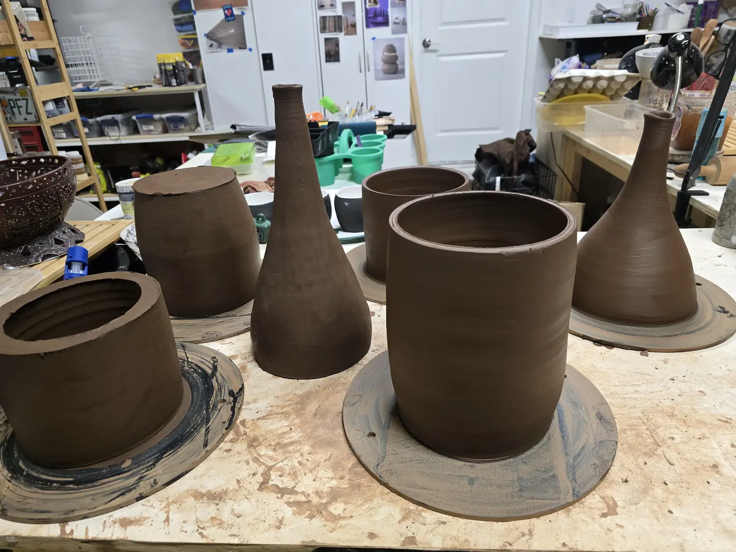 A group of freshly formed clay vessels on the studio table