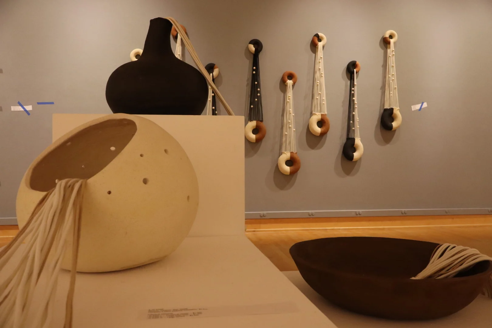 Rows of ceramic ring forms arranged on a wooden wall structure
