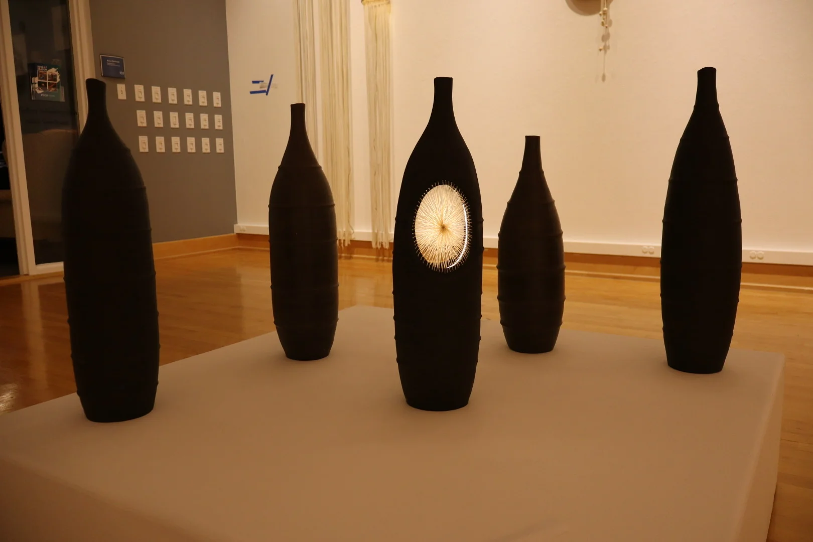 Group of hanging ring sculptures joined by thread and wooden beads